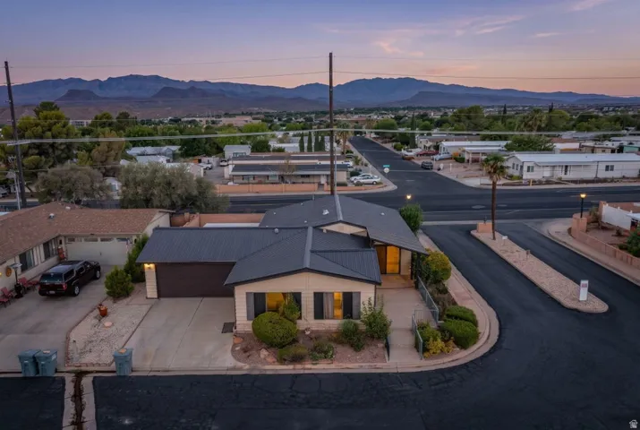 Single-story residence on a corner lot featuring a metal roof and an attached two-car garage
