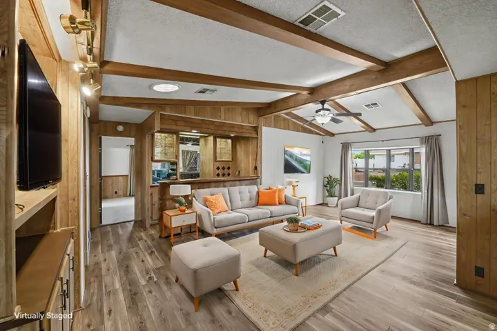 Living area featuring wood-finish flooring, exposed wood beams, and recessed lighting
