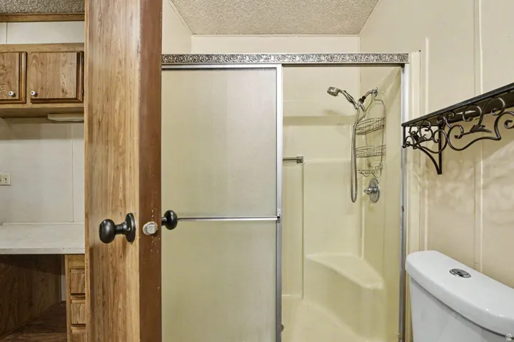 Shower stall with frosted glass sliding doors, integrated seating, and a chrome shower fixture