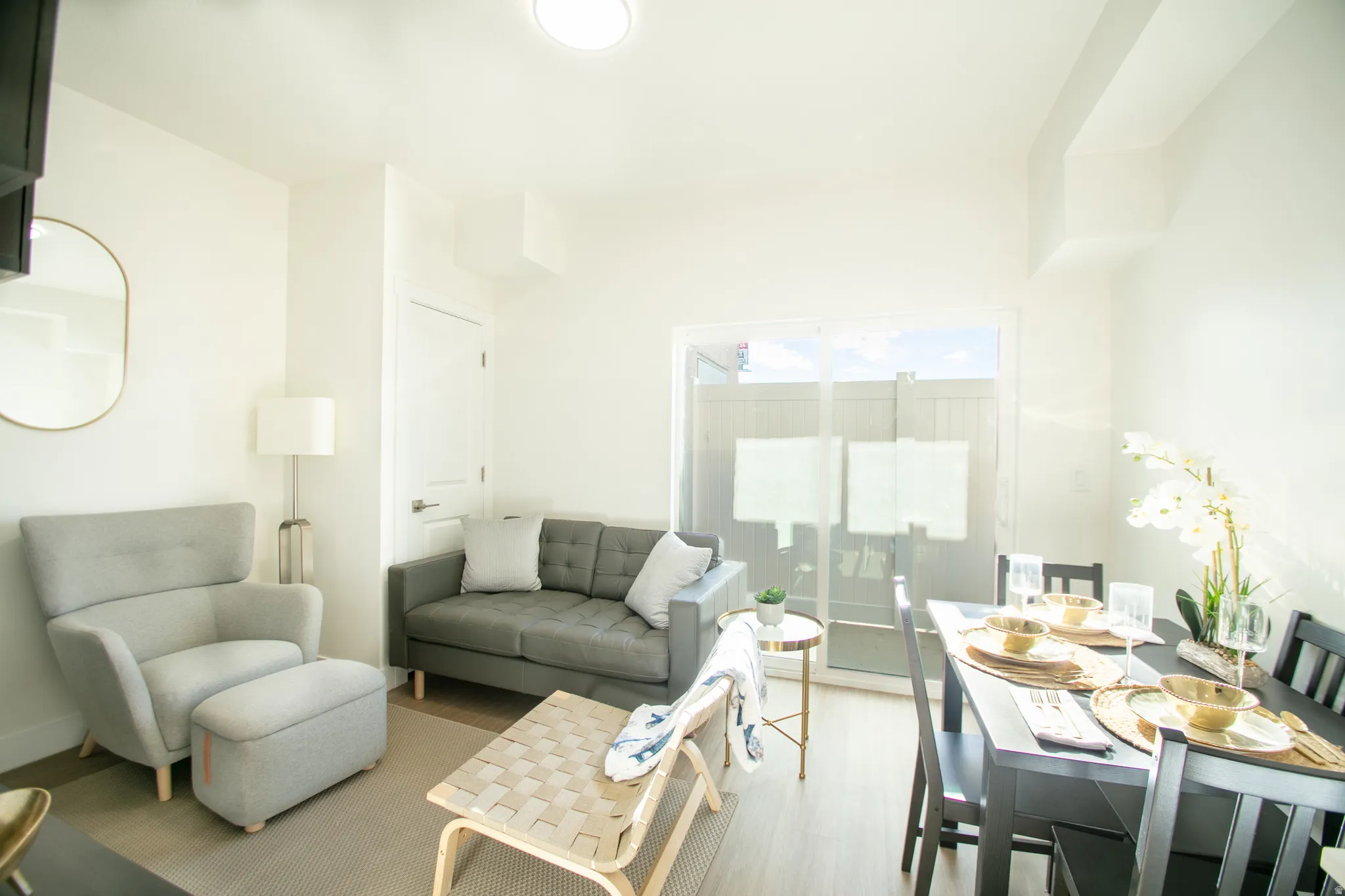 Open-concept living and dining area featuring light wood-finish flooring and white walls