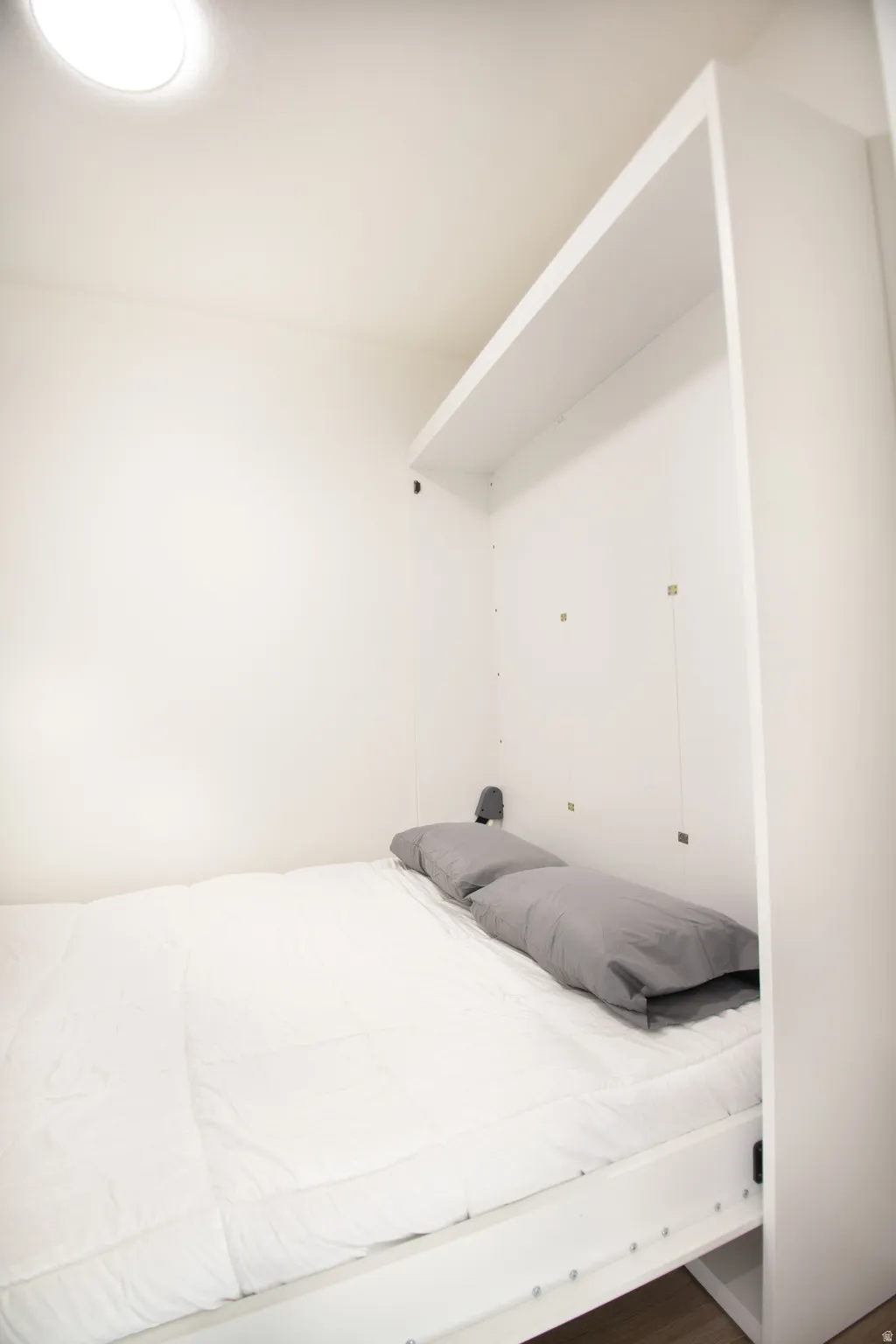 Integrated Murphy bed system with overhead shelving and recessed lighting