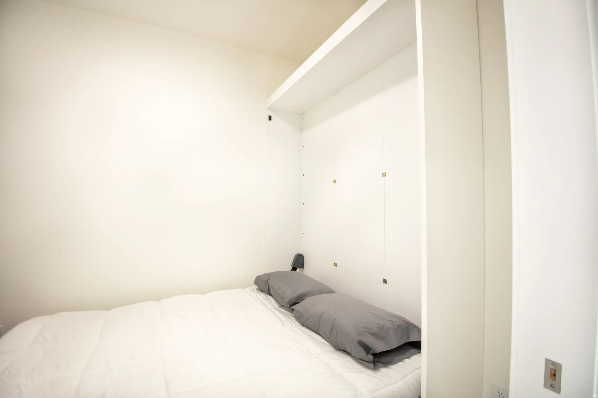 Integrated wall-mounted shelving unit with a built-in bed platform