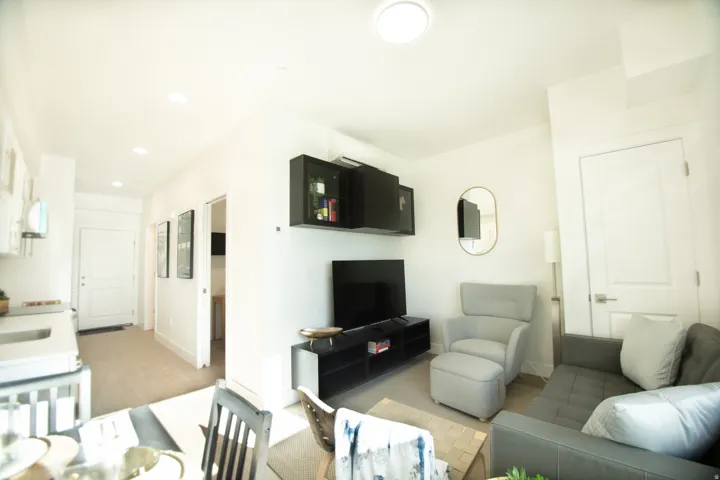 Living area featuring light flooring, white walls, recessed lighting, and a contemporary ceiling fixture