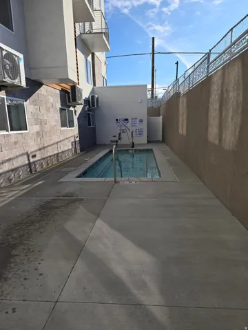 Outdoor swimming pool with integrated accessibility lift, surrounded by concrete decking