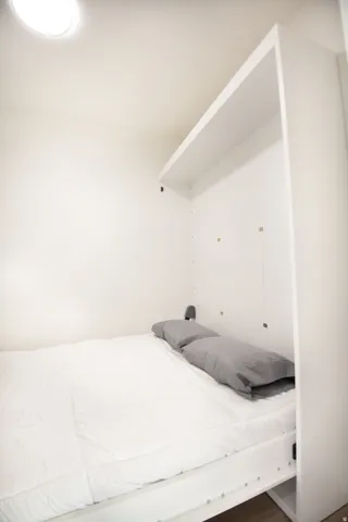 Integrated Murphy bed system with overhead shelving and recessed lighting