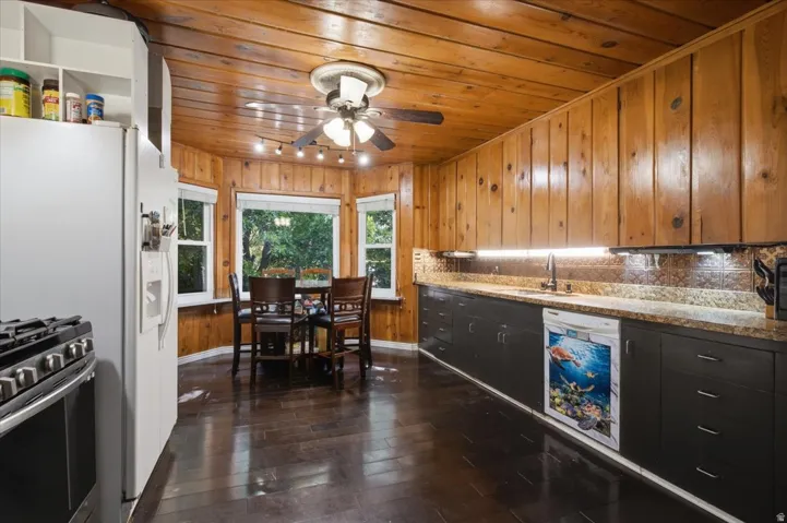 Kitchen featuring wood-finish paneling, wood-finish flooring, and a bay window