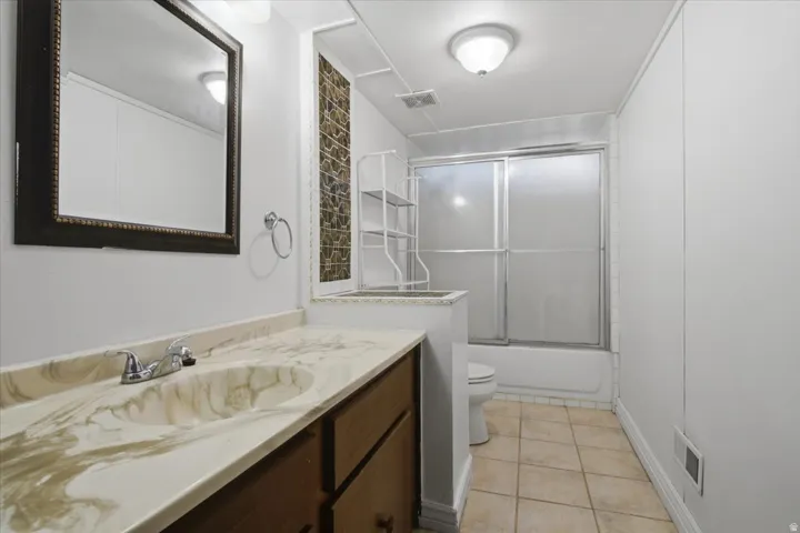 Vanity featuring a patterned countertop with integrated sink and chrome faucet