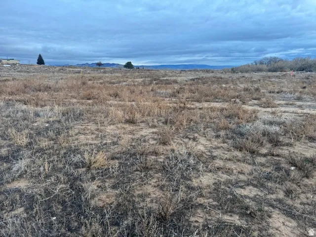 Expansive undeveloped land featuring natural terrain and distant mountainous backdrop