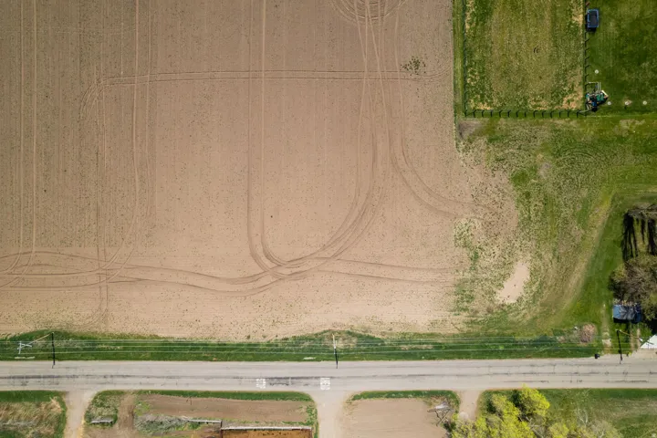 Expansive agricultural land featuring cultivated fields and green pastures