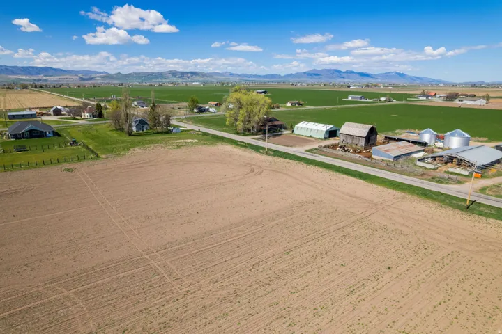 Expansive agricultural acreage featuring tilled fields and distant mountain scenery