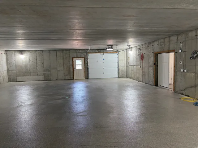 Spacious garage with an epoxy-coated concrete floor, pre-cast concrete walls, and overhead lighting