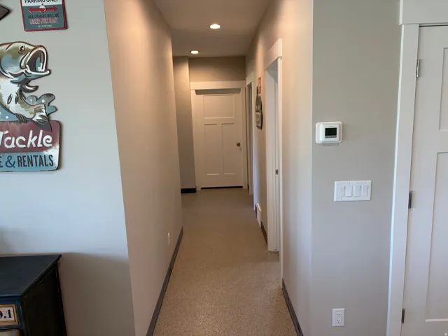 Hallway featuring recessed lighting, light-colored carpeting, white trim, and white doors