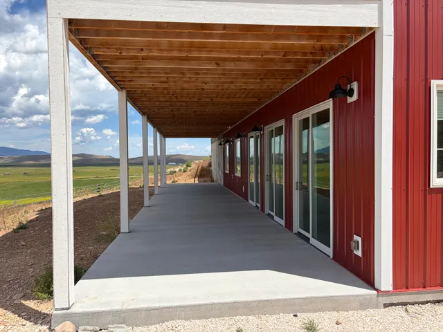 Covered concrete patio with white support columns