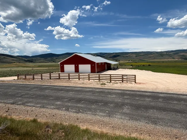Red barn-style structure featuring two prominent white garage doors