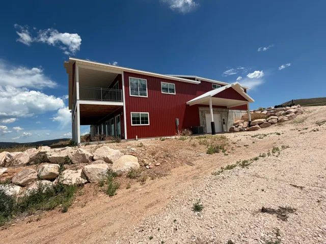 Red exterior siding featuring white trim and multiple windows