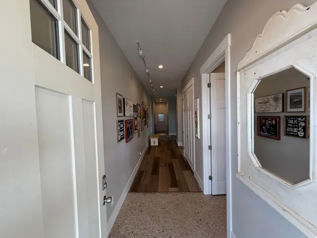 Entryway featuring a decorative mirror, wood-finish flooring, recessed lighting, and track lighting