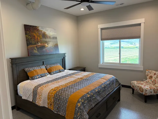 Bedroom featuring a window with cellular blinds, a ceiling fan with integrated lighting, and neutral wall tones