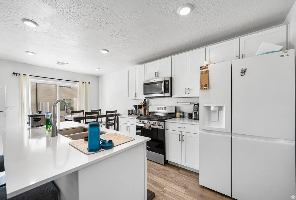 Modern kitchen featuring a white island with an integrated sink and gooseneck faucet