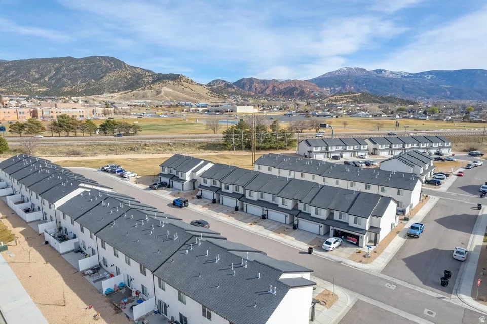 Modern townhome community featuring a consistent architectural style, individual garage access, and a mountainous backdrop