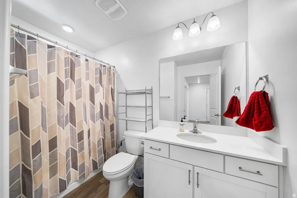 Bathroom vanity featuring a white countertop, undermount sink, and chrome faucet
