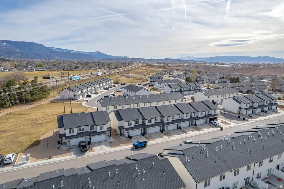 Newly constructed multi-unit properties with dark shingled roofs and light-colored siding