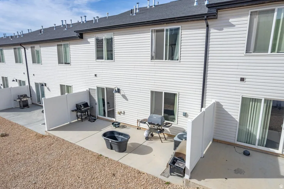 Rear exterior featuring white vinyl siding and multiple sliding glass doors