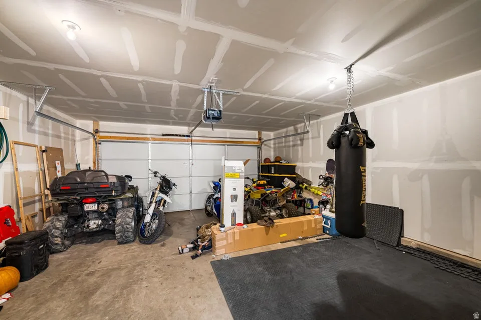 Spacious garage with unfinished walls, exposed ceiling joists, and concrete flooring