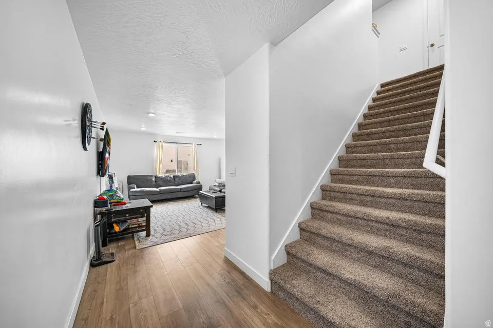 Carpeted staircase with white handrail leading to an upper level
