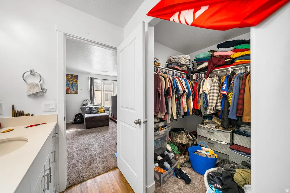 Generous walk-in closet featuring extensive built-in shelving, hanging rods, and ample storage capacity