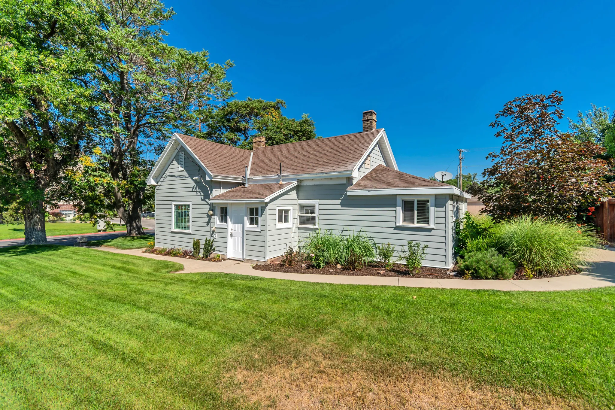 Light gray siding exterior with a brown shingle roof
