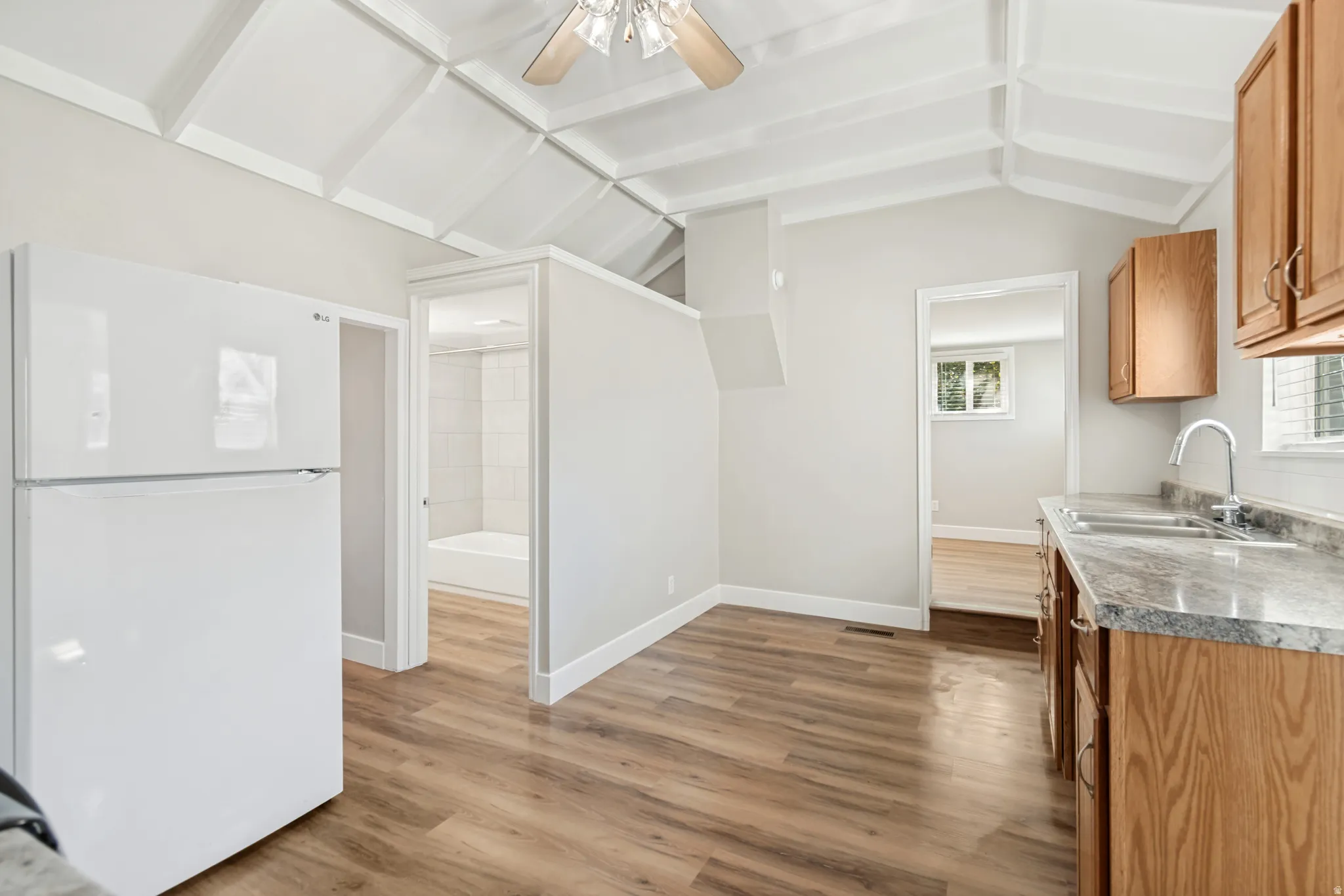 Kitchen area featuring wood-finish flooring, white walls, and a coffered ceiling