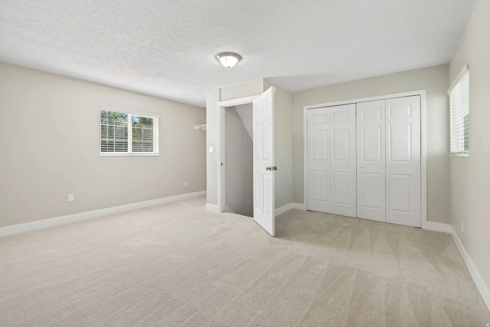 Carpeted room with neutral wall tones and white baseboards