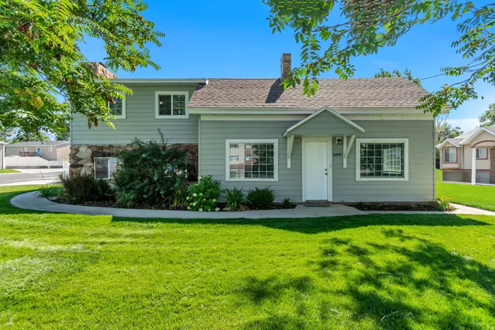 Charming single-story residence with soft green exterior siding and a welcoming front entrance