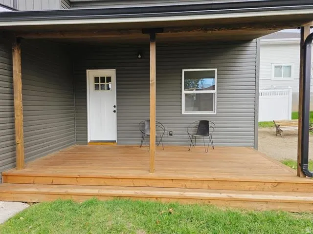 Covered porch featuring wood-finish decking and steps