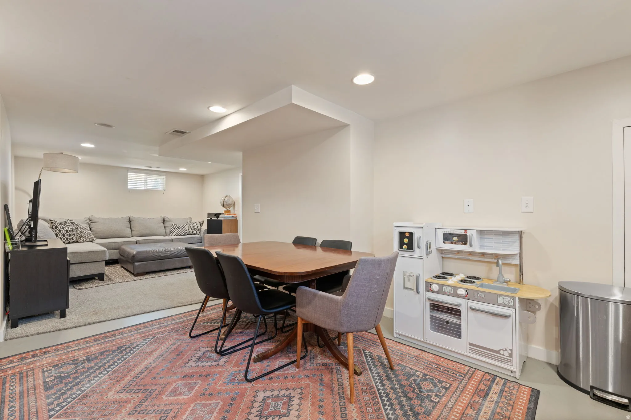 Open-concept lower level with recessed lighting, light-toned walls, and a window