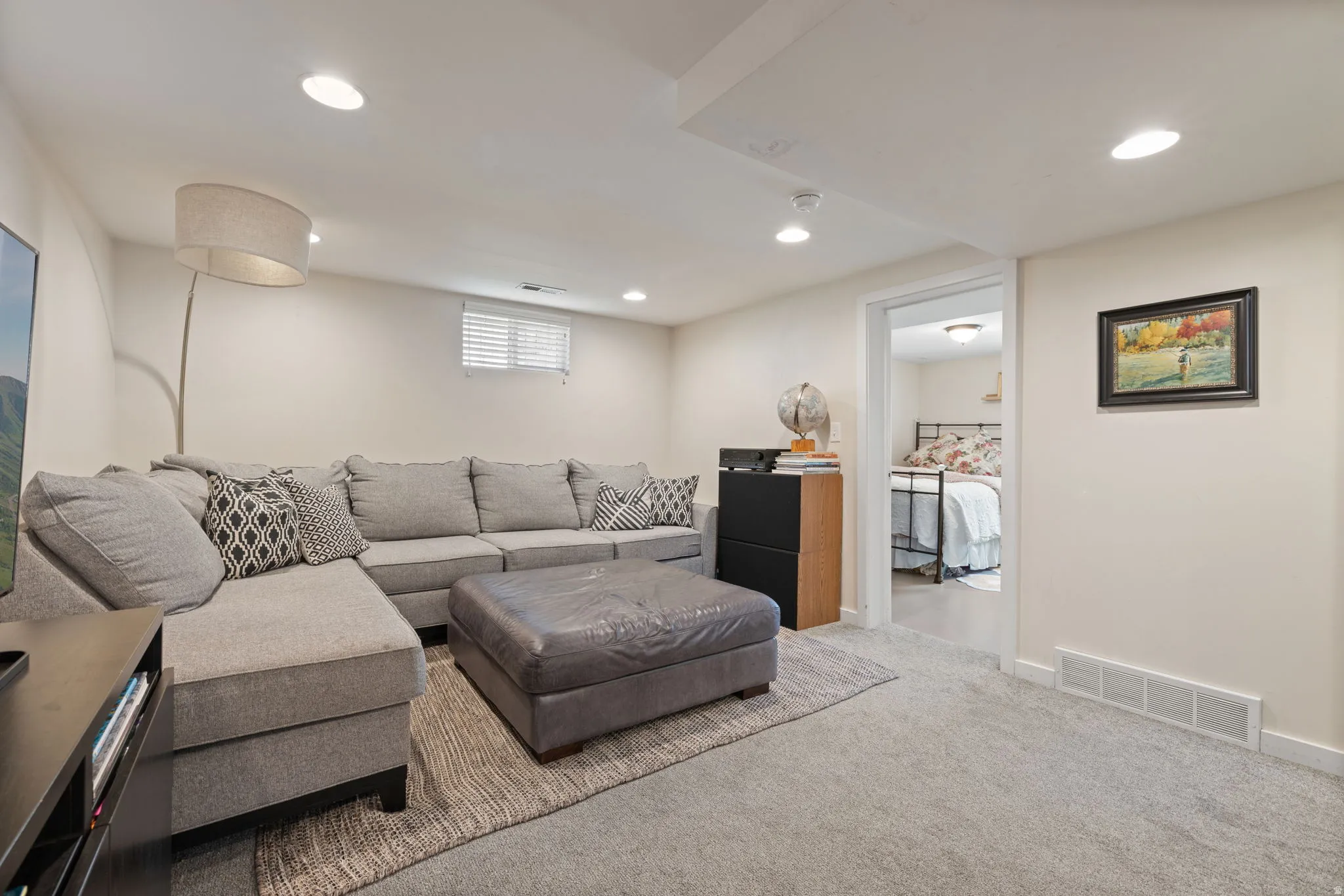 Carpeted living space with recessed lighting and a window with blinds