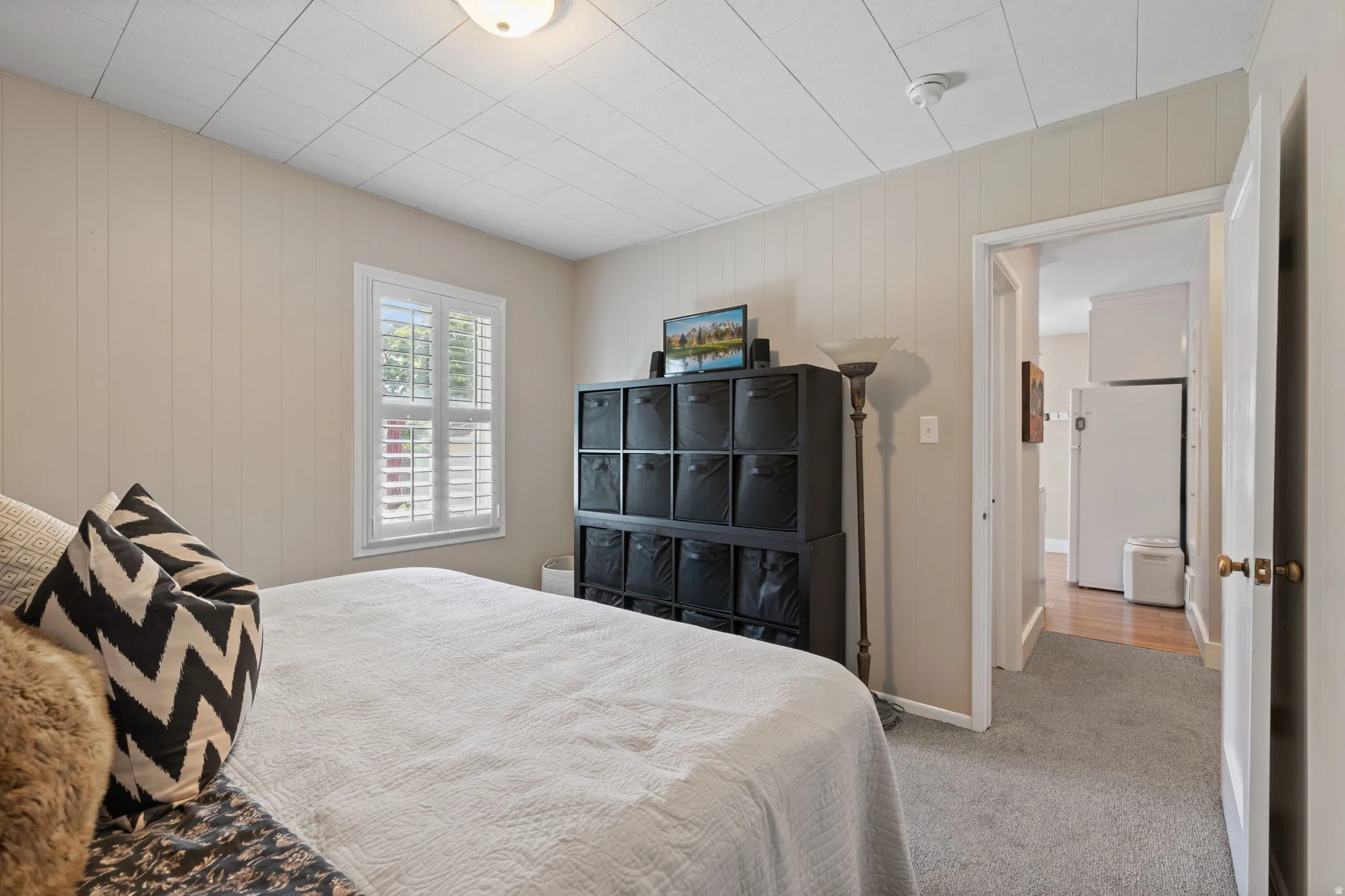 Light-colored paneling walls complement the gray carpeting