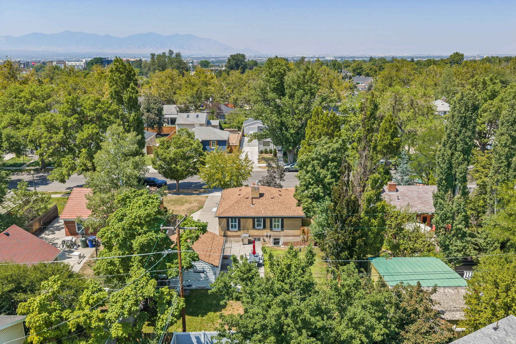 Aerial perspective highlighting a residential property with a brick exterior and a brown shingle roof