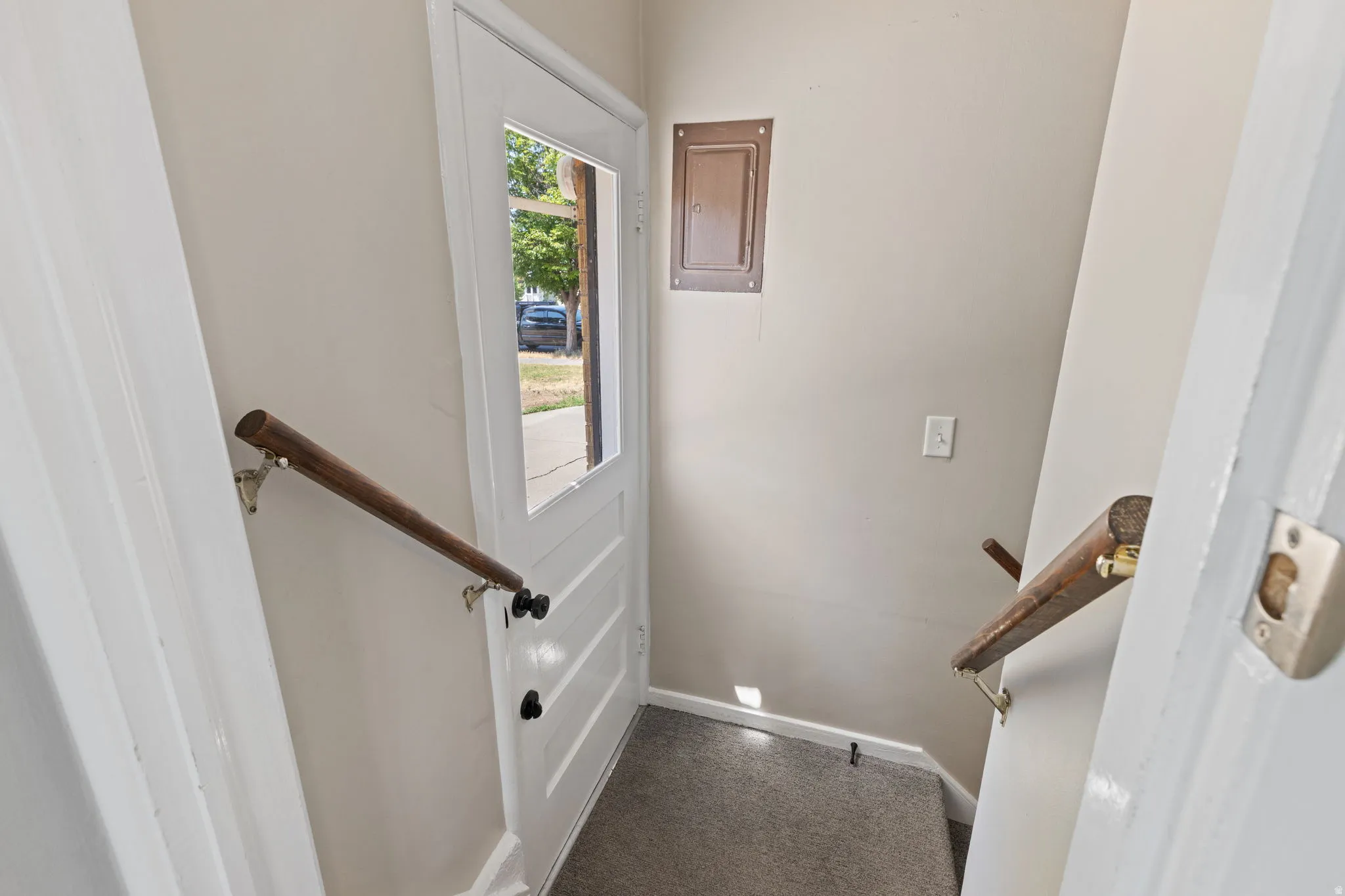Entryway with a glass-paneled door, light neutral wall paint, and carpeted flooring