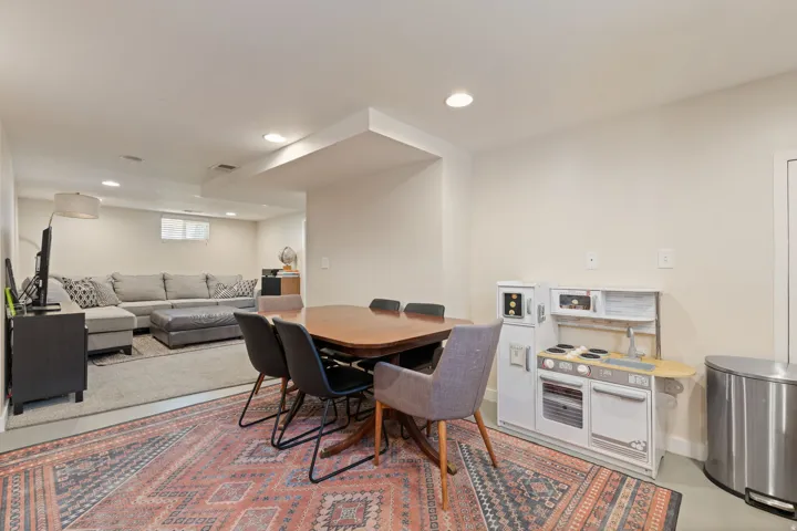 Open-concept lower level with recessed lighting, light-toned walls, and a window