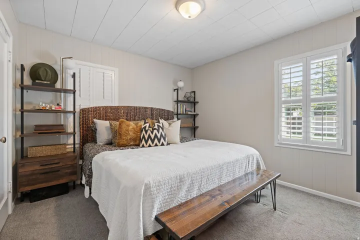 Spacious room featuring light-colored panel walls and a white paneled ceiling
