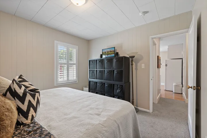Light-colored paneling walls complement the gray carpeting