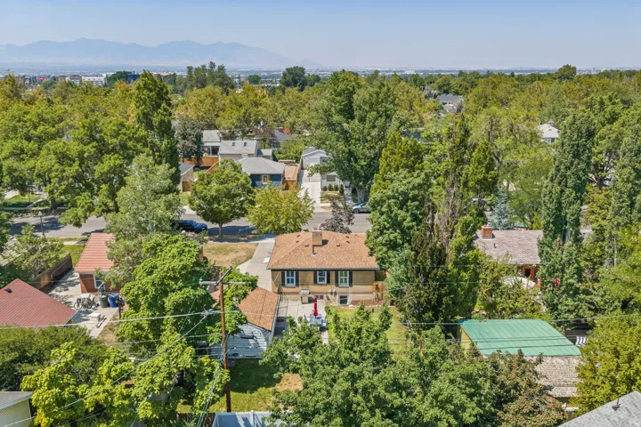 Aerial perspective highlighting a residential property with a brick exterior and a brown shingle roof