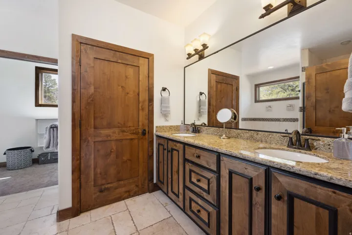Dual vanity with undermount sinks, granite countertop, and wood-finish cabinetry