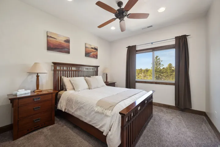 Carpeted room featuring a ceiling fan, recessed lighting, a window with a wood-finish sill, and dark window treatments