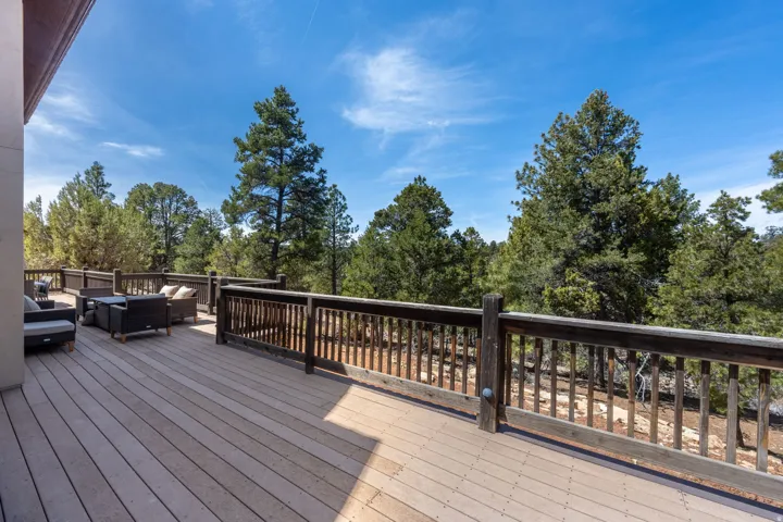 Expansive composite deck featuring multi-level wood-finish decking with black aluminum railings, offering ample space for outdoor entertaining