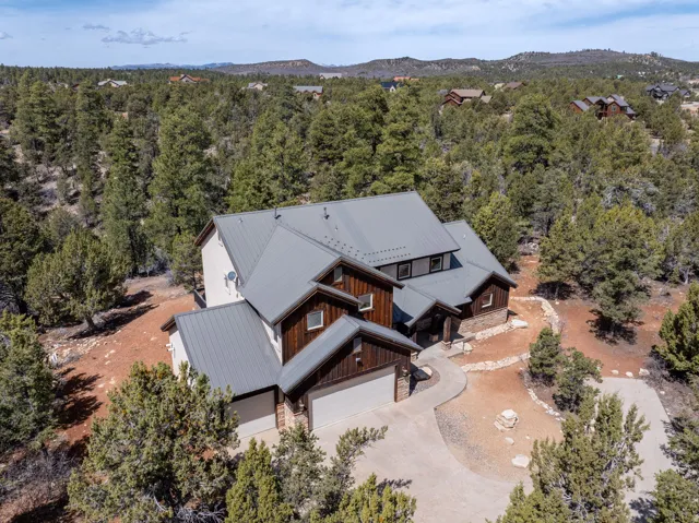 Contemporary home featuring a metal roof and light-toned siding with dark wood accents