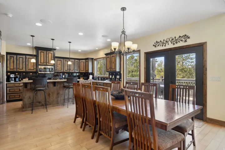 Open-concept kitchen and dining area featuring wood-finish flooring, recessed lighting, and a kitchen island with pendant lighting