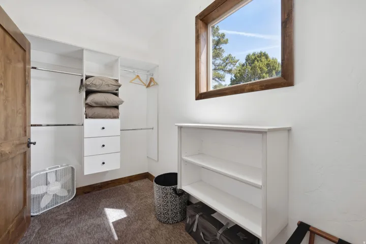 Custom closet organization system featuring white cabinetry and hanging rods