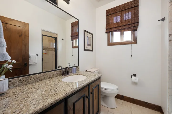 Vanity with speckled stone countertop and undermount sink